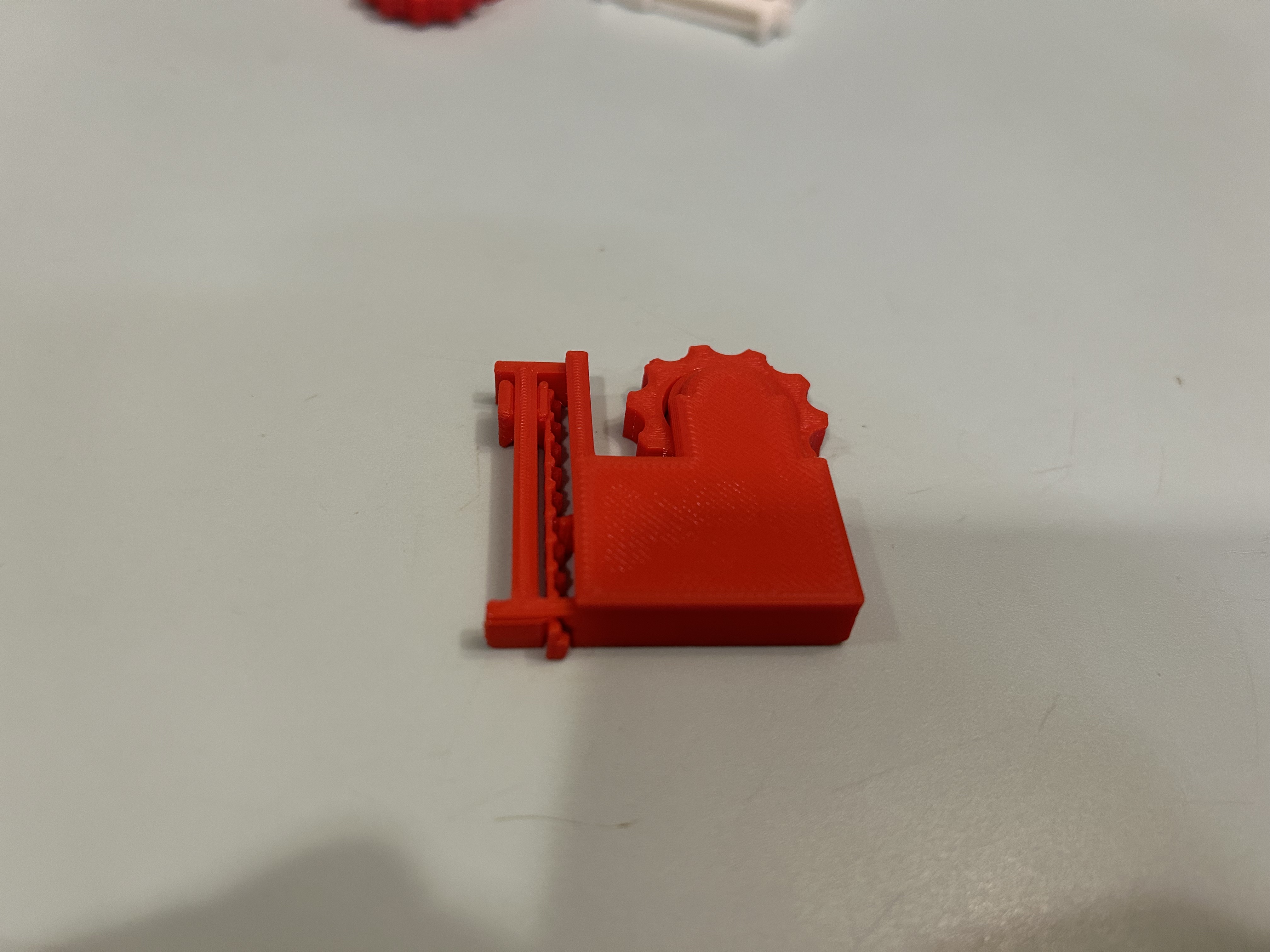 Underside of the final red fidget toy, showing the slider along the edge